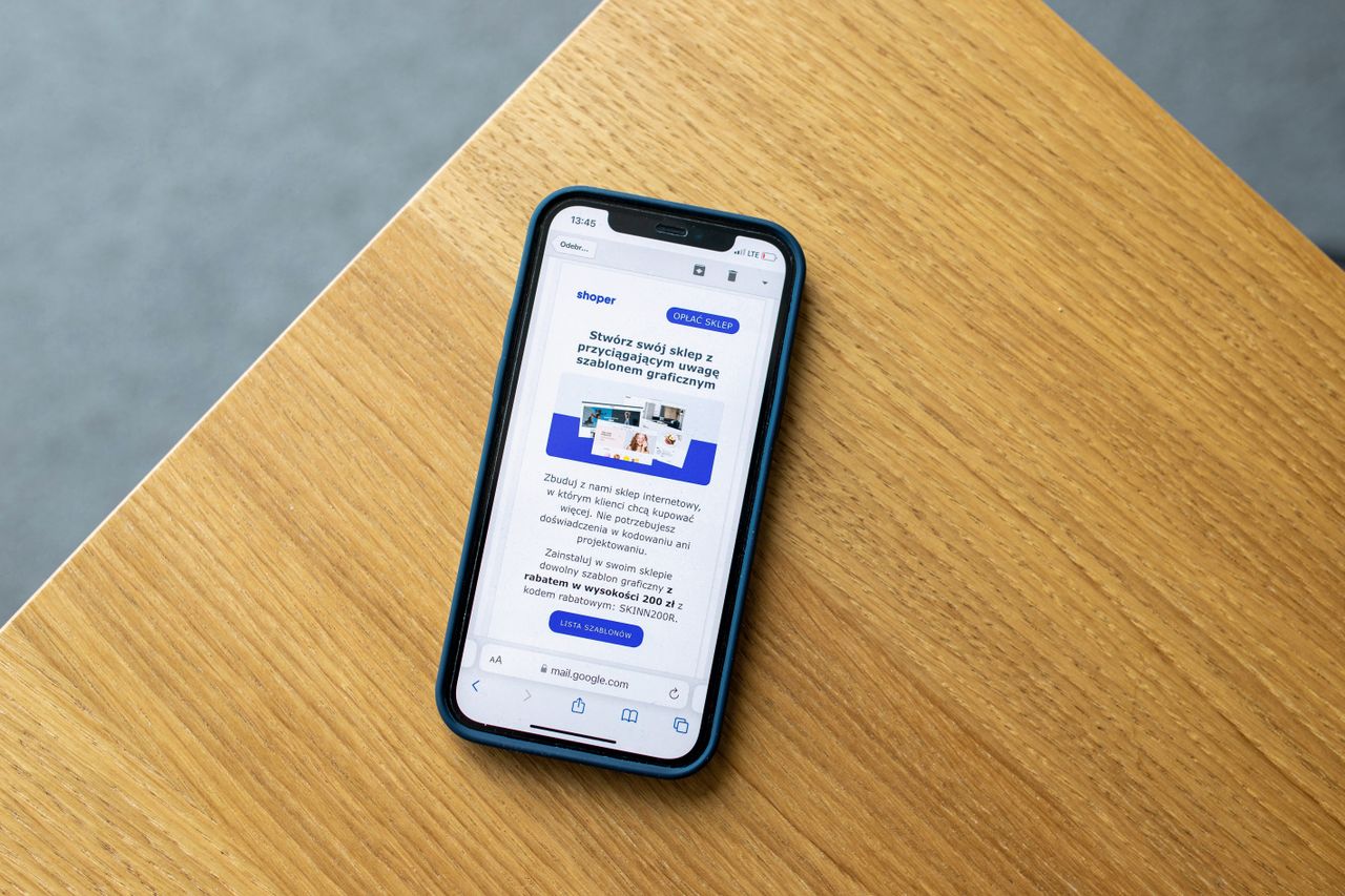 Mobile phone with an e-commerce interface on a wooden surface, illustrating online shopping technology.